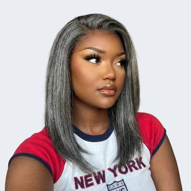 A woman modeling a straight, shoulder-length gray wig with subtle silver highlights. 